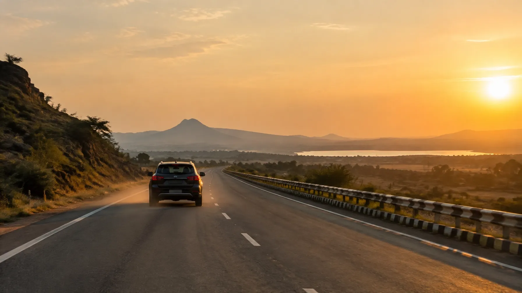 A road-trip car heading toward the hills at sunset